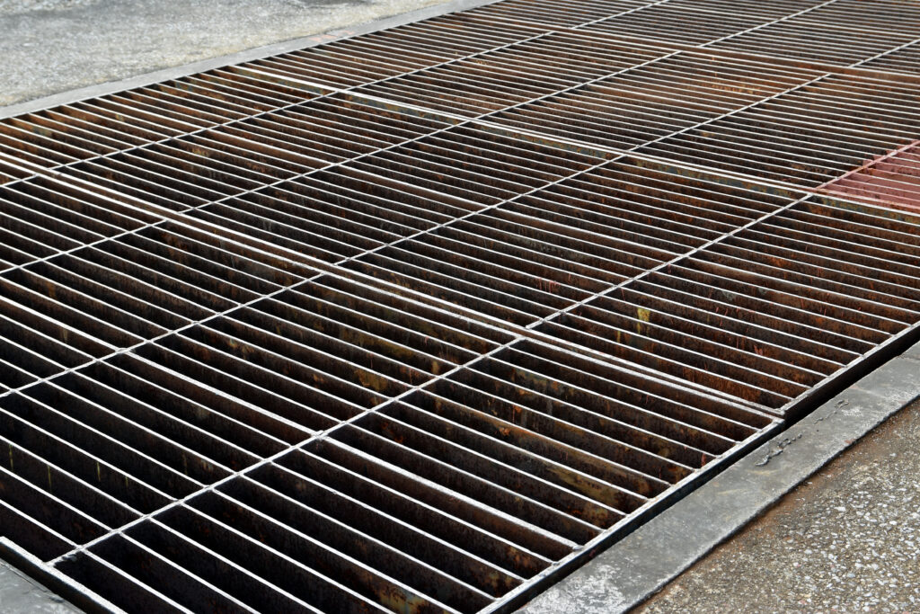 A steel grid cover on a walkway